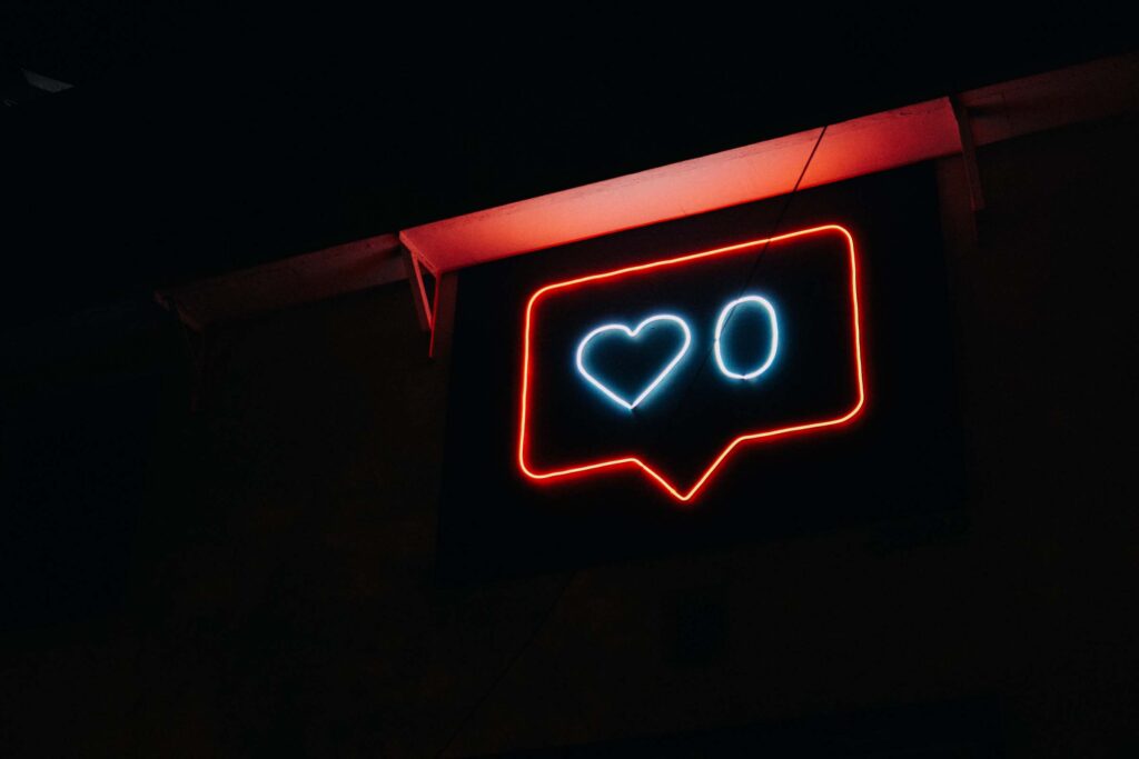 Neon sign featuring social media heart icon.